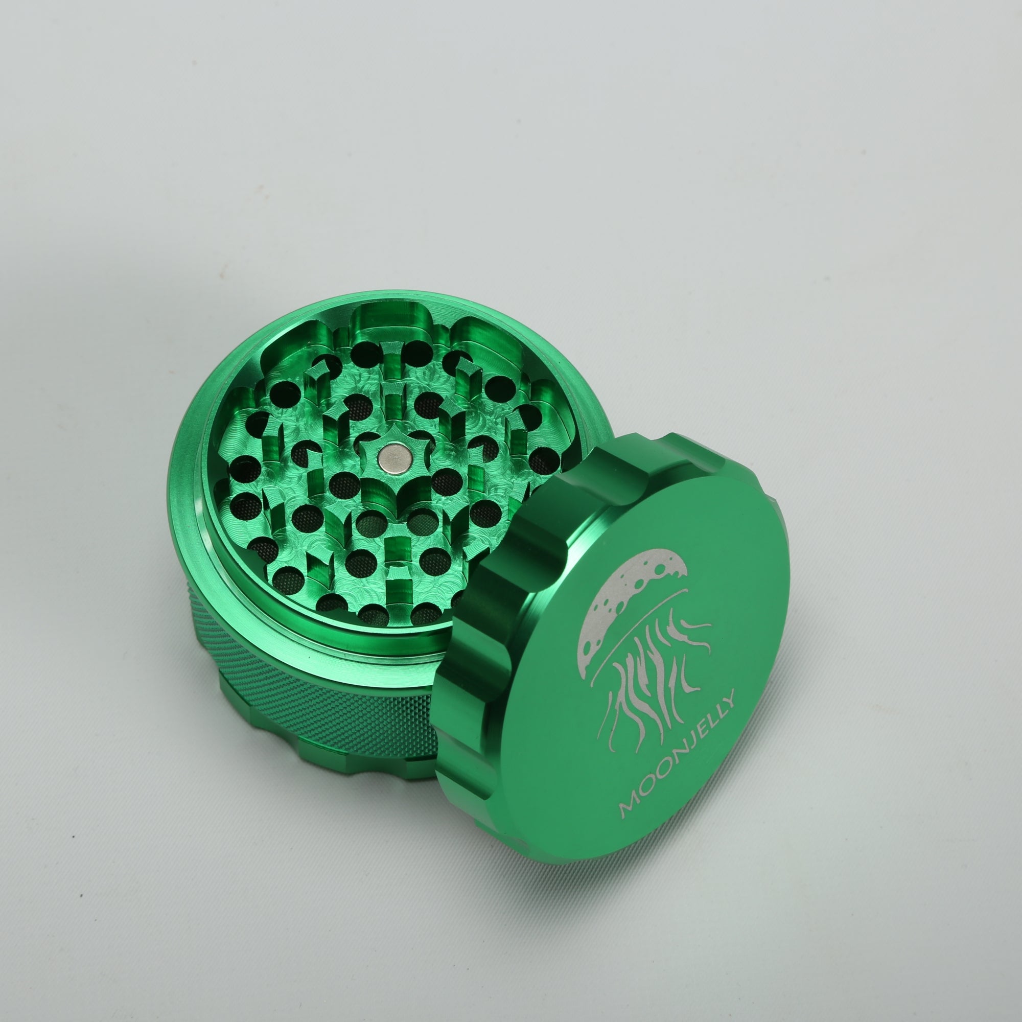 Green metal grinder with a brand logo on a light gray background