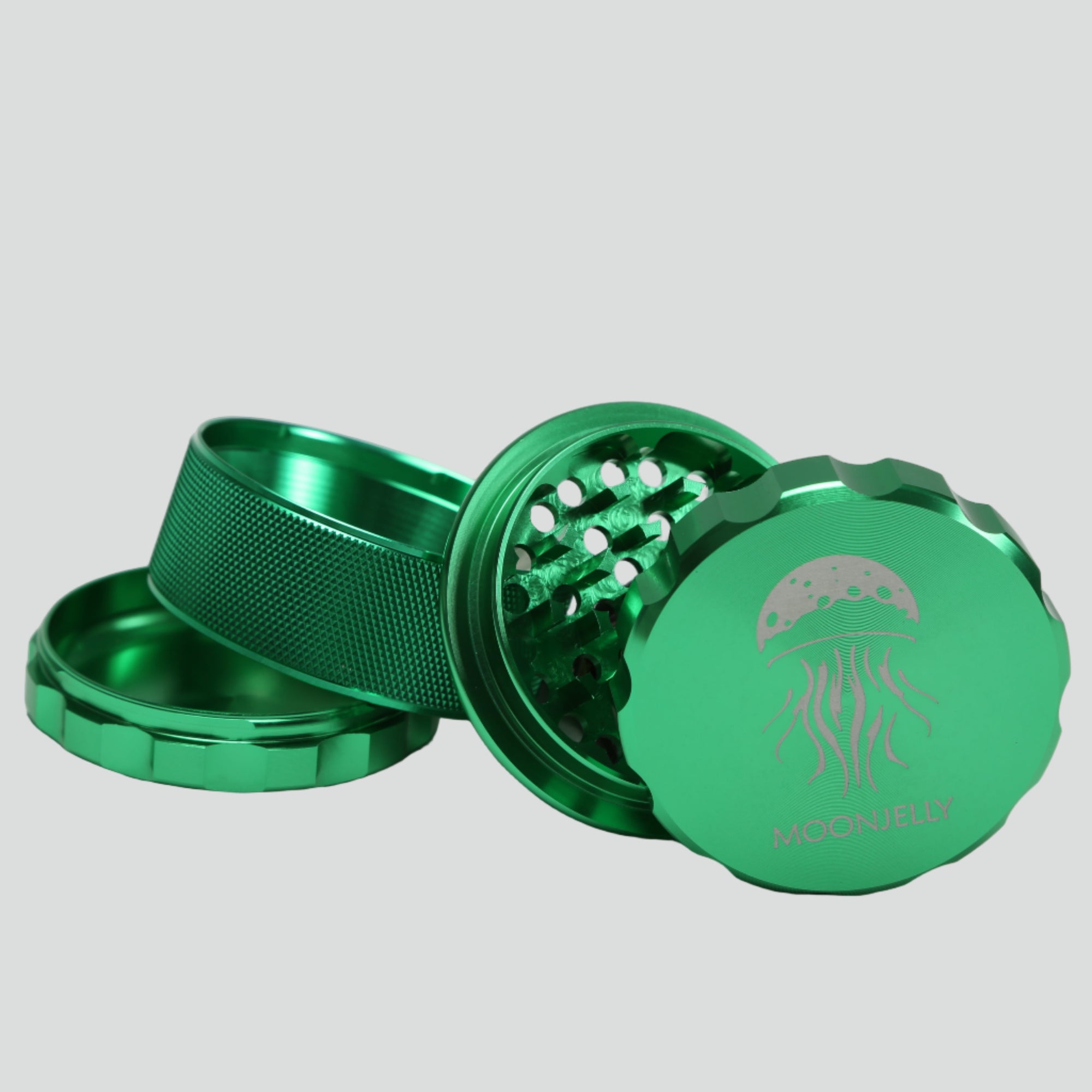 Green metal grinder with a logo on a light gray background