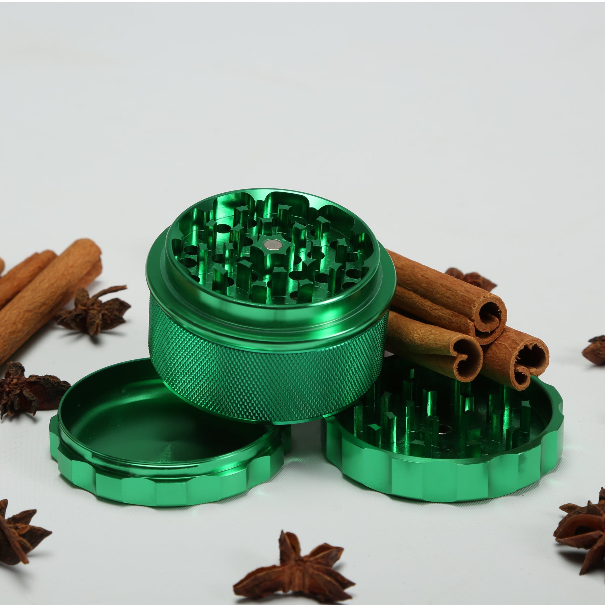 Green metal grinder with cinnamon sticks and star anise