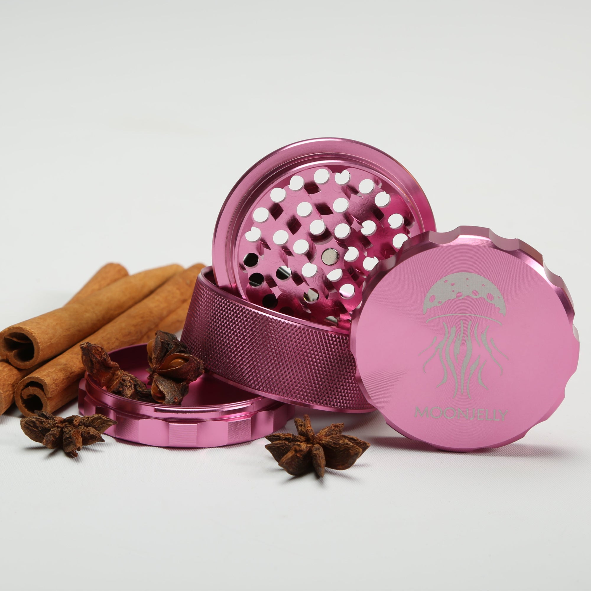 Pink metal grinder with cinnamon sticks and star anise