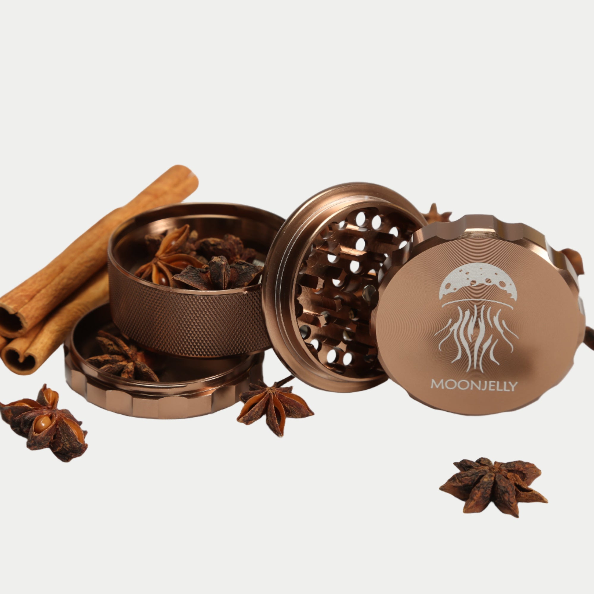 brown grinder with star anise and cinnamon sticks, featuring the Moonjelly brand.