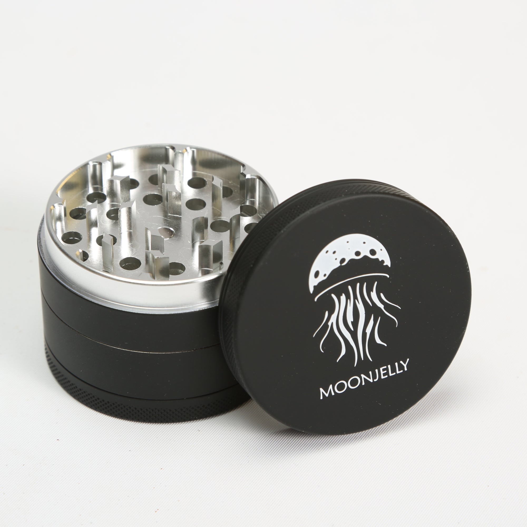 Black and silver grinder with MoonJelly logo on a white background