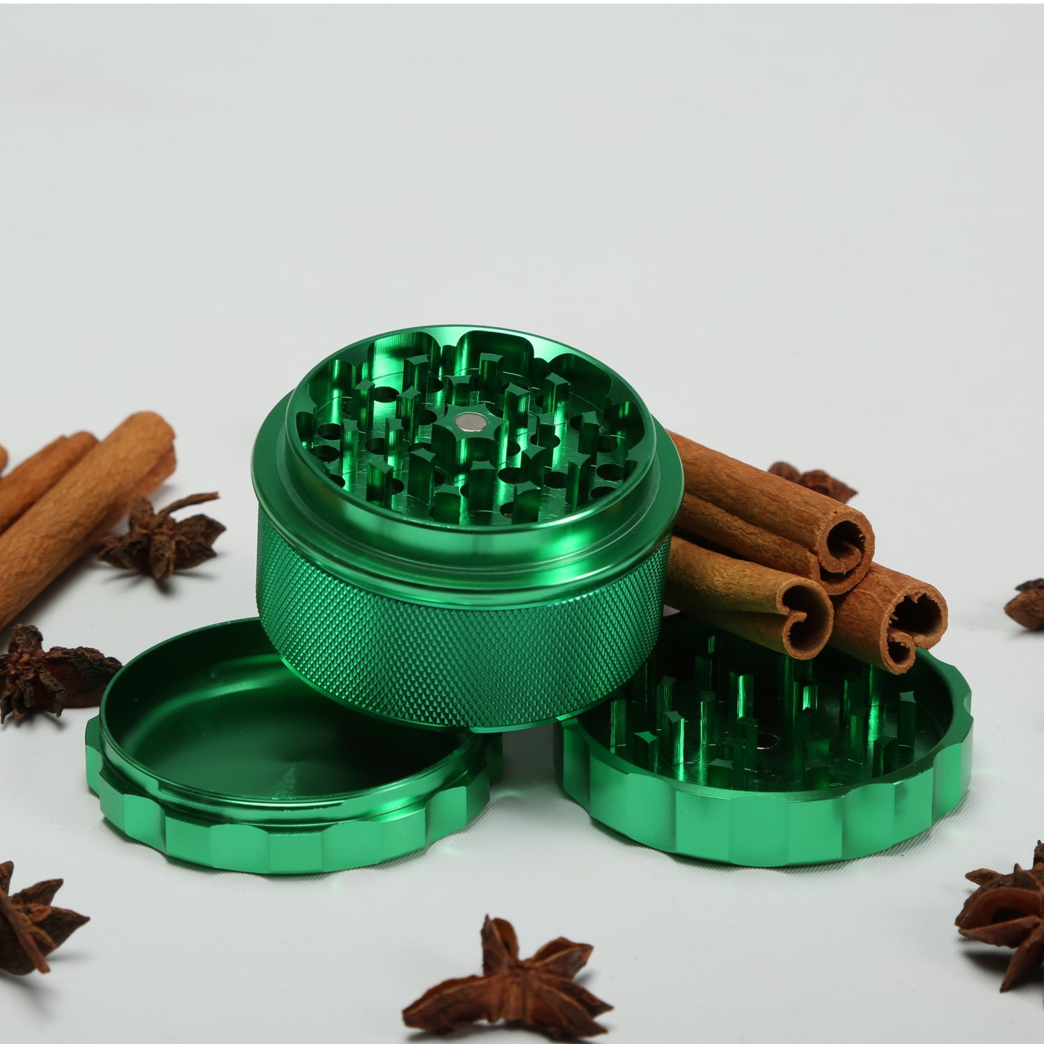 Green metal grinder with cinnamon sticks and star anise 