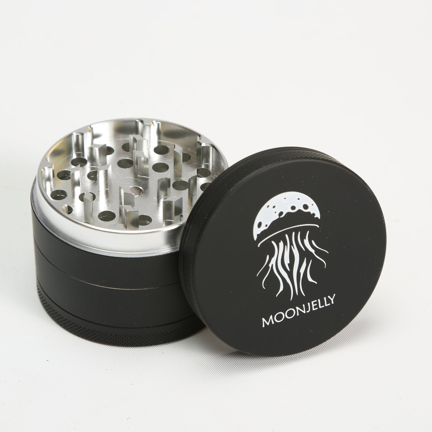 Black and silver grinder with MoonJelly logo on a white background 