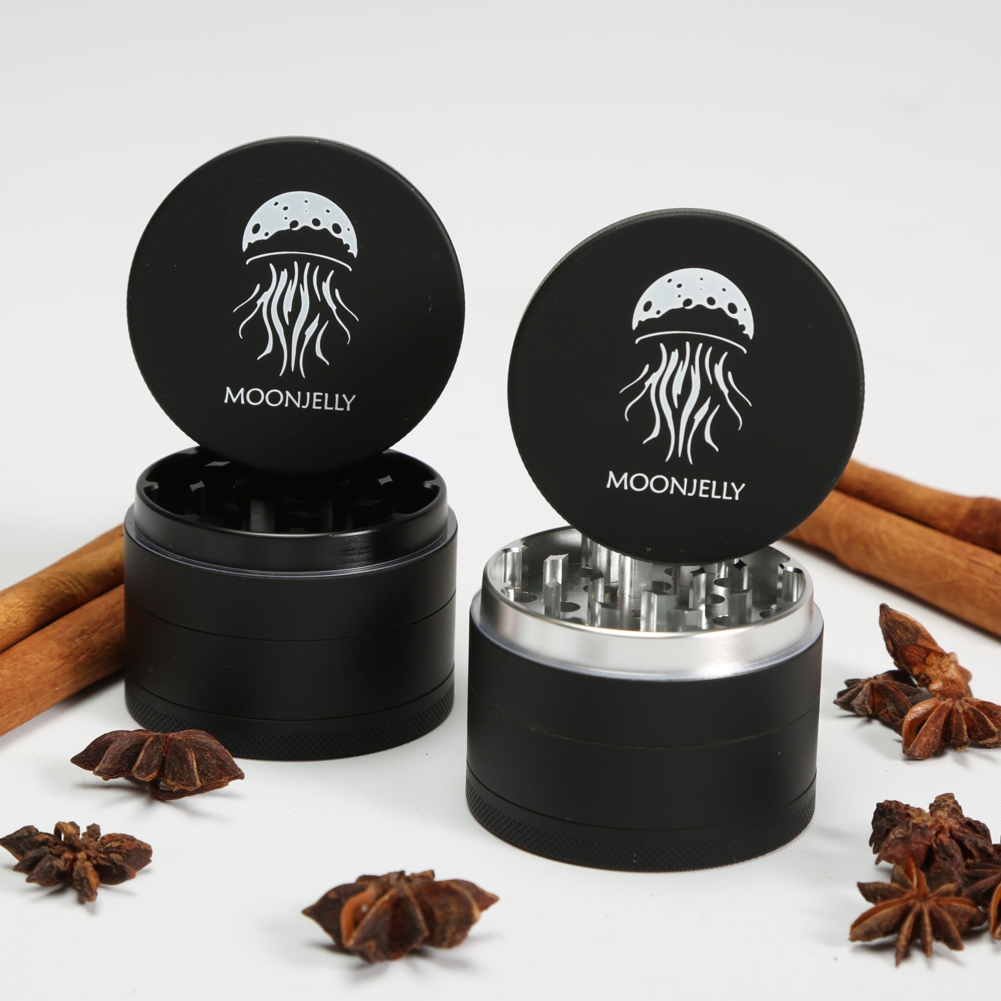 Black MOONEELLY grinder with cinnamon sticks and star anise on a white background 